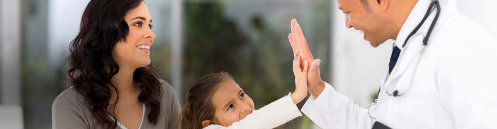 A doctor high-fiving a child while the child’s mom smiles